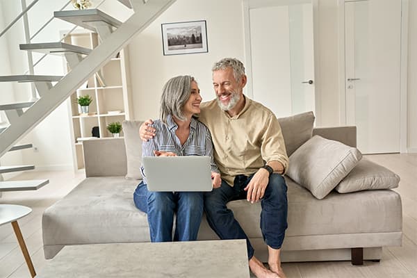 Happy-senior-mature-family-couple-using-laptop-computer-at-home